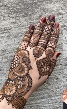 a woman's hand with henna tattoos on it