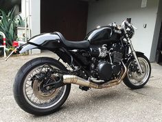 a black motorcycle parked in front of a garage