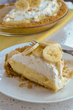 a slice of banana cream pie on a white plate with a fork next to it