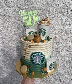 a starbucks cake with coffee cups and cookies on top for someone's 50th birthday