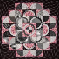 a black and white quilt with circles on the center, in pink and grey colors