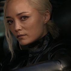 a close up of a person in a car wearing a black leather jacket and looking at the camera