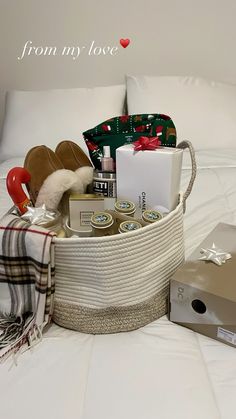 a basket filled with gifts on top of a bed next to a pillow and blanket