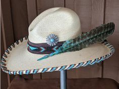 The Thunderbird starts with a Mexican soft palm Gus hat body that has a 4" brim and 5 1/2" crown. Hand laced in three colors of leather lace - chocolate brown, turquoise and saddle. The beaded hatband has a thunderbird pattern and is mounted on chocolate suede. The back of the band has a deer antler bead for accent. Large antiqued Concho with a faux turquoise stone. A massive barred turkey feather dyed in turquoise completes the hat. All hats are made to order. Allow up to 4 weeks for your hat t Antler Beads, Jordan Hats, Couture Hats, Hat Holder, Painted Hats, Rancher Hat, Beaded Hat, Turquoise Accents, Diy Hat