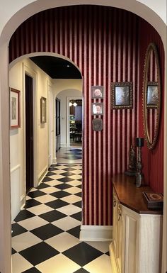 the hallway is decorated with red and white striped wallpaper, black and white checkered floor