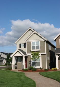 two story house with front yard and walkway leading up to the garage doors on each side