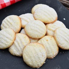 a pile of sugar cookies sitting on top of a black plate