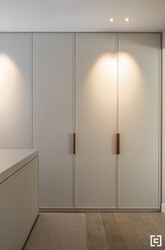 an empty room with white cupboards and lights