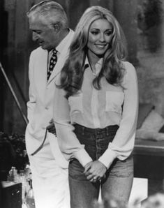 an old black and white photo of a man and woman standing next to each other