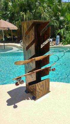 a sculpture made out of skateboards in front of a swimming pool