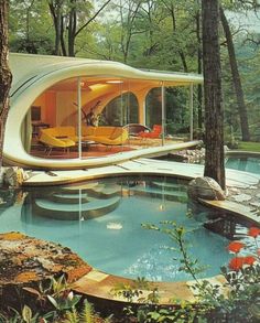 an unusual house in the woods with a pool and lounge chairs on it's side