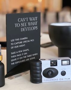 a camera sitting next to a sign that says can't wait to see what develops