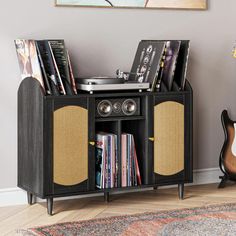 an entertainment center with record players and records on it in front of a wall mounted painting