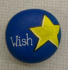 a blue rock with a yellow star and the word wish painted on it's side