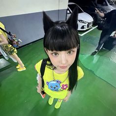 a girl with long black hair wearing a yellow shirt