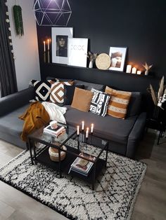 a black and white living room with candles on the coffee table in front of it