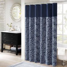 a bathroom with a sink, mirror and shower curtain in blue colors on the wall