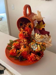 an orange plate topped with pumpkins and other decorations