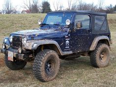 an old jeep is parked in a field with mud on the tires and hoods