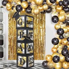 a black and gold party decoration with balloons