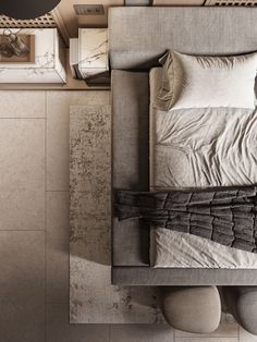 an overhead view of a bed with pillows and blankets on it, next to a night stand