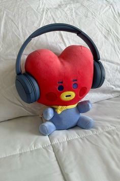 a stuffed animal with headphones on sitting on a bed