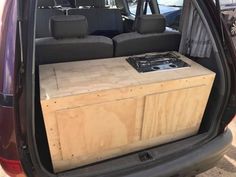 an open trunk in the back of a car with two seats and a table on top