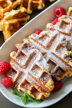 waffles with powdered sugar and raspberries on a plate