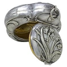 an ornate silver and gold ring with flowers on the inside, sitting in front of a white background