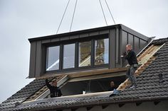 a man standing on the roof of a house