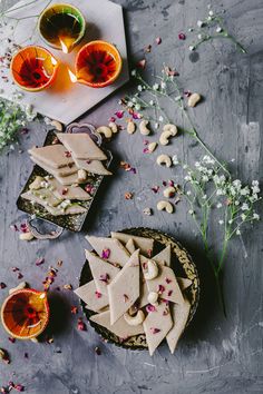 some food is sitting on a table next to cups and glasses with flowers in them