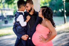 a man and woman pose for a photo while holding their son