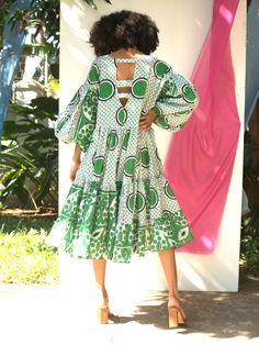 Doreen Mashika incorporates the palette and prints of her native Zanzibar into the design of this Nia Dress. Refreshed for the SS’22 season in a new green colorway, it’s been crafted using the Kanga fabrics, proudly produced by the Swahili community. It has a relaxed silhouette, a flattering V-neck, and a playful high-low hem. For maximum impact, style yours with a pair of heels in a tonal hue. - V-neck, long sleeves with gathered cuffs, tiered skirt, high-low hem, pockets- Cotton- Each piece is Ankara Long Dress, Lagos Fashion Week, Floaty Dress, Glamorous Party, African Wear, Black Prom Dresses, New Green, Tier Skirt, Layered Look