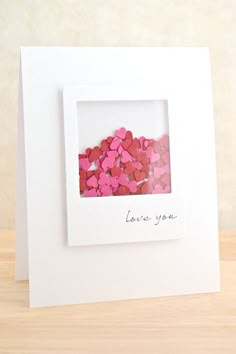 a white card with pink and red hearts in it