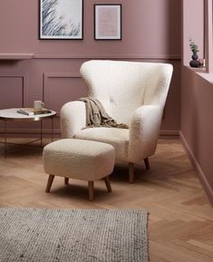 a chair and ottoman in a room with pink walls