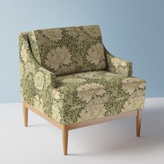 a green and white chair sitting on top of a white floor next to a blue wall