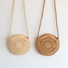 two round purses hanging on the wall, one is made out of rope and the other has a crochet pattern