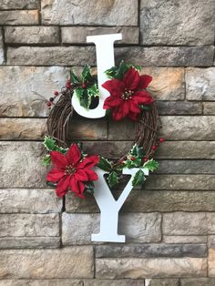 the letter y is decorated with poinsettis and greenery in front of a brick wall