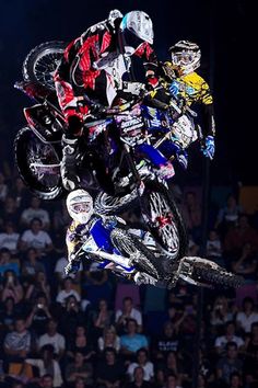 two motorcyclists in the air doing tricks on their bikes at an event