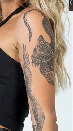 a woman with a tattoo on her arm and shoulder is looking at the camera while wearing a black top