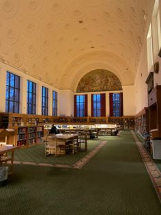 the interior of a large library with many tables and bookshelves on each side