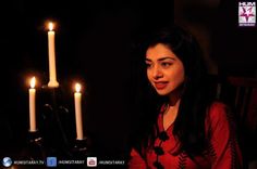 a woman sitting in front of two lit candles