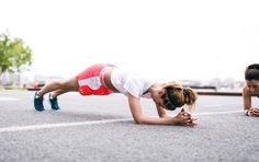 a woman in white shirt and red skirt doing push ups on the street with blue shoes