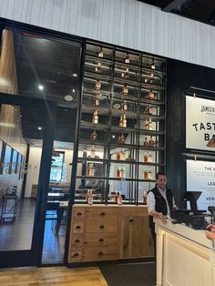 a man standing behind a counter in front of a bar