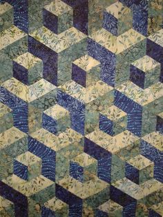 a blue and yellow quilt with an abstract design