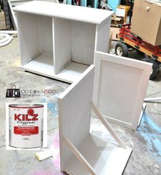 two white cabinets with one open and the other closed next to a can of paint