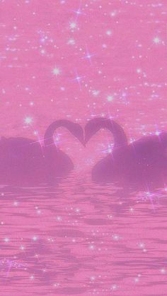 two swans in the water making a heart shape with their necks and eyes covered by sparkles