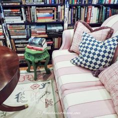 a living room filled with lots of books and furniture