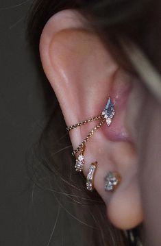 a close up of a person's ear with three different types of piercings