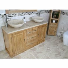 a bathroom with two sinks and a toilet in the corner, next to a wooden cabinet